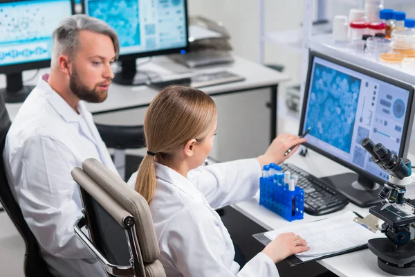 Professioneel team van wetenschappers werkt aan een vaccin in een modern wetenschappelijk onderzoekslaboratorium. Genetische ingenieur werkplek. Toekomstige technologie en wetenschap. — Stockfoto