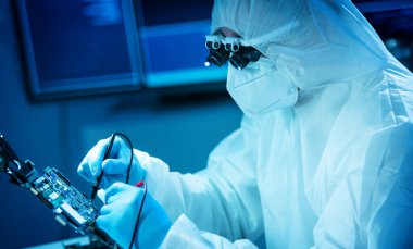 Bilim adamı mikro elektronik ve işlemcilerin araştırılması ve geliştirilmesi için modern bir bilim laboratuvarında çalışıyor. Mikroişlemci imalat işçisi bilgisayar teknolojisi ve ekipmanı kullanıyor.