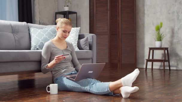 Young woman orders goods online using a laptop and a credit card. Online shopping, delivery and payment systems concept. — Stock Video