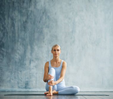 Spor giyimli genç, narin sarışın kadın geniş bir eğitim odasında fitness yapıyor. Spor, sağlık, jimnastik ve yaşam tarzı konsepti.