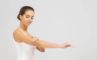 Stüdyoda poz veren beyaz mayo giymiş genç, fit ve güzel esmer kadın. Sağlık, diyet, spor ve spor.