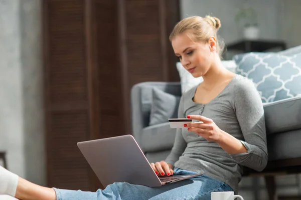 Junge Frau bestellt Waren online mit Laptop und Kreditkarte. Konzept für Online-Einkaufs-, Liefer- und Zahlungssysteme. — Stockfoto