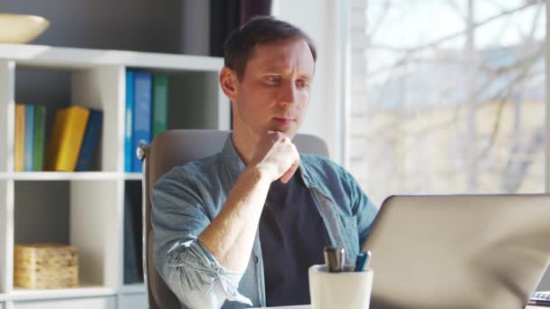 Joven empresario masculino trabaja en la oficina en casa en la computadora. Lugar de trabajo del freelancer o estudiante. Trabajo remoto y concepto de educación. — Vídeos de Stock