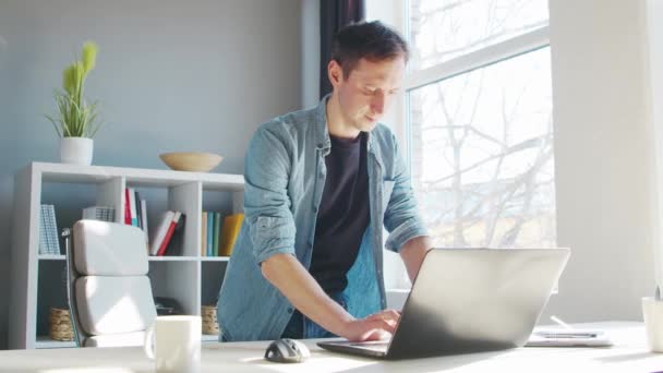 Jonge mannelijke ondernemer werkt op kantoor thuis aan de computer. Werkplaats van freelancer of student. Het begrip "telewerk en onderwijs". — Stockvideo