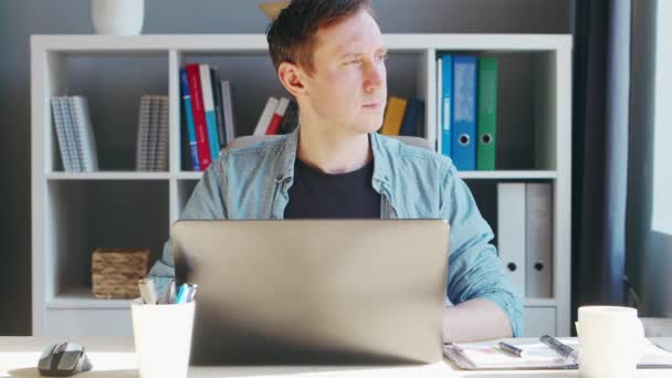 Jeune entrepreneur masculin travaille au bureau à domicile à l'ordinateur. Lieu de travail de pigiste ou d'étudiant. Concept de télétravail et d'éducation. — Video