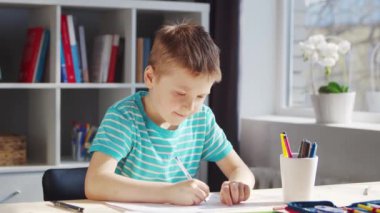 Çocuk Masa 'da ödevini yapıyor. Şirin Çocuk, Ders kitapları ve okul malzemelerinin yardımıyla evde öğreniyor. Öğrenim ve Eğitim Konsepti.