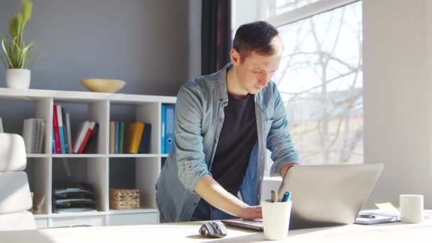 Jonge mannelijke ondernemer werkt op kantoor thuis aan de computer. Werkplaats van freelancer of student. Het begrip "telewerk en onderwijs". — Stockvideo