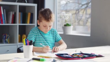 Çocuk Masa 'da ödevini yapıyor. Şirin Çocuk, Ders kitapları ve okul malzemelerinin yardımıyla evde öğreniyor. Öğrenim ve Eğitim Konsepti.