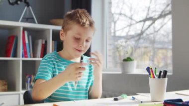 Çocuk Masa 'da ödevini yapıyor. Şirin Çocuk, Ders kitapları ve okul malzemelerinin yardımıyla evde öğreniyor. Öğrenim ve Eğitim Konsepti.