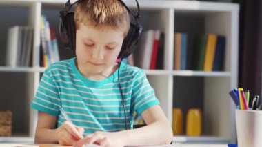 Çocuk Masa 'da ödevini yapıyor. Şirin Çocuk, Ders kitapları ve okul malzemelerinin yardımıyla evde öğreniyor. Öğrenim ve Eğitim Konsepti.