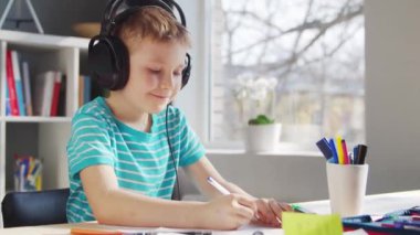 Çocuk Masa 'da ödevini yapıyor. Şirin Çocuk, Ders kitapları ve okul malzemelerinin yardımıyla evde öğreniyor. Öğrenim ve Eğitim Konsepti.