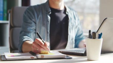 Genç erkek girişimci bilgisayarın merkez ofisinde çalışıyor. Serbest çalışan ya da öğrencilerin çalıştığı yer. Uzak çalışma ve eğitim kavramı.