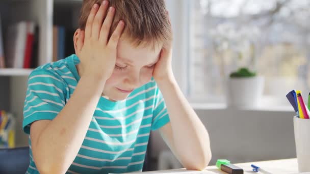 Boy fait ses devoirs à la table. Cute Child apprend à la maison à l'aide de manuels scolaires et de matériel scolaire. Concept d'étude et d'éducation. — Video