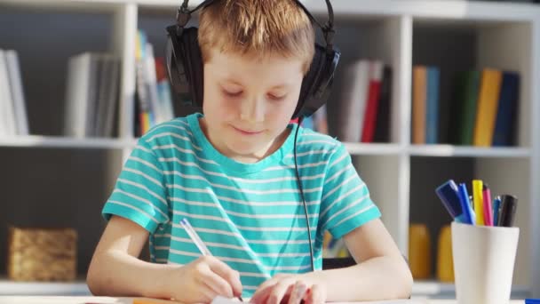 Il ragazzo sta facendo i compiti a tavola. Cute Child sta imparando a casa con l'aiuto di libri di testo e materiali scolastici. Concetto di studio e istruzione. — Video Stock
