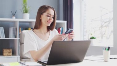Genç Kadın İç İşleri 'nde Bilgisayar ve Smertphone kullanarak çalışıyor. Kadın Girişimci, Freelancer ya da Öğrenci 'nin işyeri. Uzaktan Çalışma ve Eğitim Konsepti.