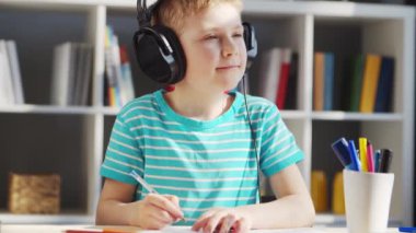 Çocuk Masa 'da ödevini yapıyor. Şirin Çocuk, Ders kitapları ve okul malzemelerinin yardımıyla evde öğreniyor. Öğrenim ve Eğitim Konsepti.