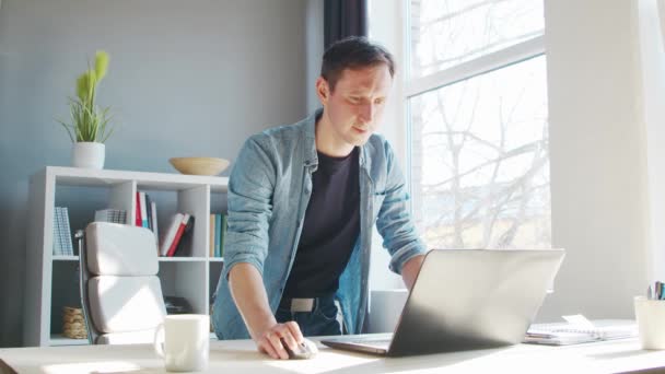 Joven empresario masculino trabaja en la oficina en casa en la computadora. Lugar de trabajo del freelancer o estudiante. Trabajo remoto y concepto de educación. — Vídeos de Stock