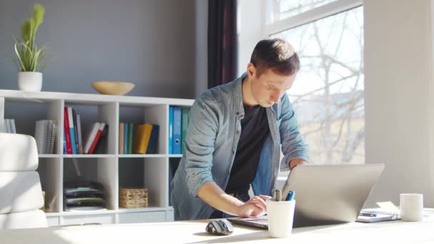 Fiatal férfi vállalkozó dolgozik otthon iroda a számítógép. Szabadúszó vagy diák munkahelye. Távmunka és oktatási koncepció. — Stock videók