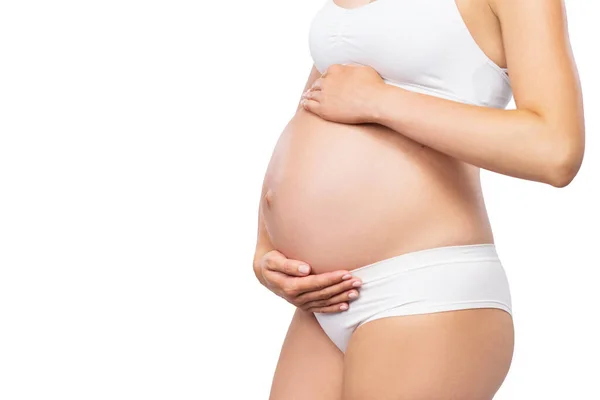 Jovem grávida de fato de banho. Menina esperando um bebê e tocando sua barriga isolada no fundo branco. Imagem de close-up. — Fotografia de Stock