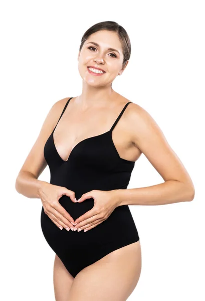 Jonge zwangere vrouw in zwart badpak. meisje verwacht een baby en aanraken van haar buik geïsoleerd op witte achtergrond. — Stockfoto