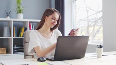 Genç Kadın İç İşleri 'nde Bilgisayar ve Smertphone kullanarak çalışıyor. Kadın Girişimci, Freelancer ya da Öğrenci 'nin işyeri. Uzaktan Çalışma ve Eğitim Konsepti.