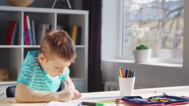 Çocuk Masa 'da ödevini yapıyor. Şirin Çocuk, Ders kitapları ve okul malzemelerinin yardımıyla evde öğreniyor. Öğrenim ve Eğitim Konsepti.
