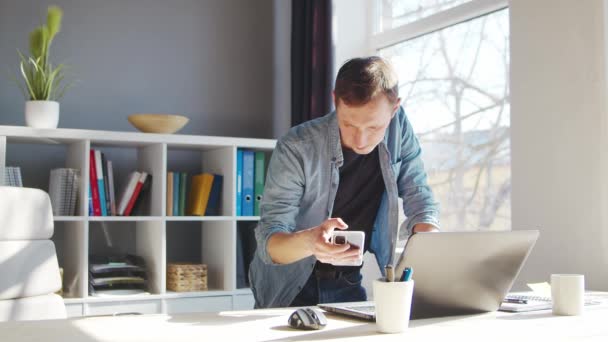 Jeune entrepreneur masculin travaille au bureau à domicile à l'ordinateur. Lieu de travail de pigiste ou d'étudiant. Concept de télétravail et d'éducation. — Video