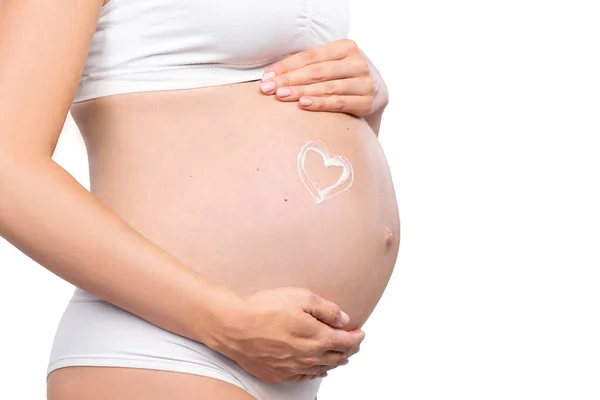 Jovem grávida de fato de banho. Menina esperando um bebê e tocando sua barriga isolada no fundo branco. Imagem de close-up. — Fotografia de Stock