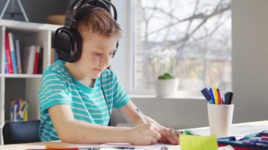 Çocuk Masa 'da ödevini yapıyor. Şirin Çocuk, Ders kitapları ve okul malzemelerinin yardımıyla evde öğreniyor. Öğrenim ve Eğitim Konsepti.