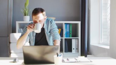 Genç erkek girişimci bilgisayarın merkez ofisinde çalışıyor. Serbest çalışan ya da öğrencilerin çalıştığı yer. Uzak çalışma ve eğitim kavramı.