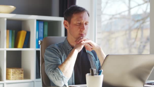 Jeune entrepreneur masculin travaille au bureau à domicile à l'ordinateur. Lieu de travail de pigiste ou d'étudiant. Concept de télétravail et d'éducation. — Video