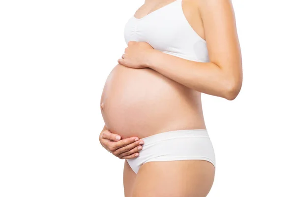 Jovem grávida de fato de banho. Menina esperando um bebê e tocando sua barriga isolada no fundo branco. Imagem de close-up. — Fotografia de Stock