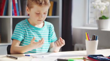 Çocuk Masa 'da ödevini yapıyor. Şirin Çocuk, Ders kitapları ve okul malzemelerinin yardımıyla evde öğreniyor. Öğrenim ve Eğitim Konsepti.