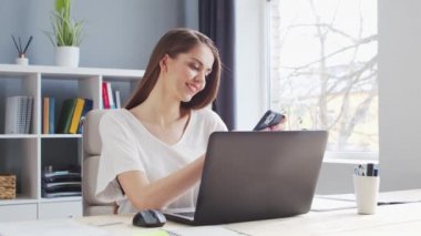 Genç Kadın İç İşleri 'nde Bilgisayar ve Smertphone kullanarak çalışıyor. Kadın Girişimci, Freelancer ya da Öğrenci 'nin işyeri. Uzaktan Çalışma ve Eğitim Konsepti.