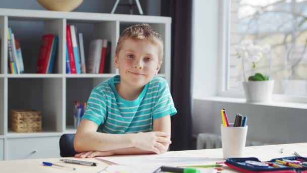 Chlapec si dělá domácí úkoly u stolu. Roztomilé dítě se učí doma pomocí učebnic a školních materiálů. Koncepce studia a vzdělávání. — Stock video