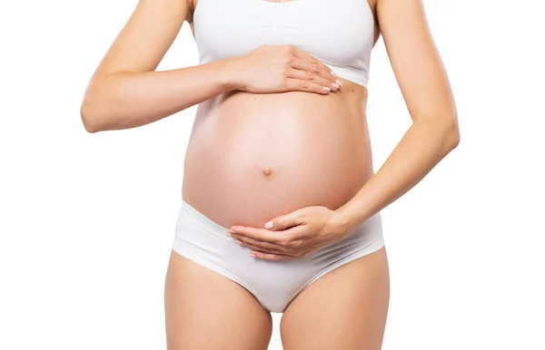 Jovem grávida de fato de banho. Menina esperando um bebê e tocando sua barriga isolada no fundo branco. Imagem de close-up. — Fotografia de Stock
