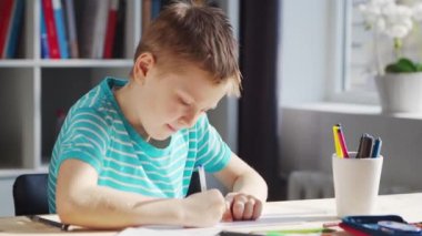 Çocuk Masa 'da ödevini yapıyor. Şirin Çocuk, Ders kitapları ve okul malzemelerinin yardımıyla evde öğreniyor. Öğrenim ve Eğitim Konsepti.