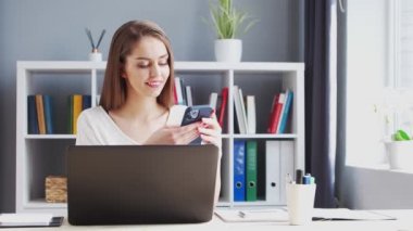 Genç Kadın İç İşleri 'nde Bilgisayar ve Smertphone kullanarak çalışıyor. Kadın Girişimci, Freelancer ya da Öğrenci 'nin işyeri. Uzaktan Çalışma ve Eğitim Konsepti.