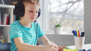 Çocuk Masa 'da ödevini yapıyor. Şirin Çocuk, Ders kitapları ve okul malzemelerinin yardımıyla evde öğreniyor. Öğrenim ve Eğitim Konsepti.