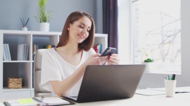 Bilgisayarla evden çalışan genç bir kadın. Kadın Girişimci, Serbest Çalışan ya da Öğrenci İşyeri. 