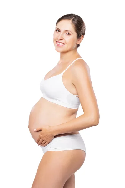 Jovem grávida de fato de banho. Menina esperando um bebê e tocando sua barriga isolada no fundo branco. — Fotografia de Stock
