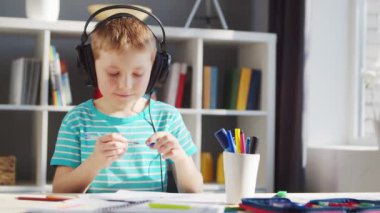 Çocuk Masa 'da ödevini yapıyor. Şirin Çocuk, Ders kitapları ve okul malzemelerinin yardımıyla evde öğreniyor. Öğrenim ve Eğitim Konsepti.