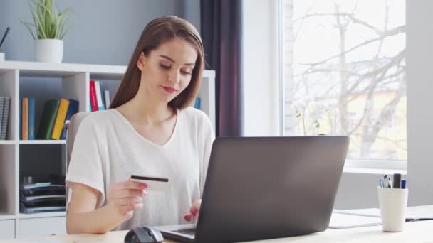 Young Woman maakt online aankopen op het internet met behulp van een bankkredietkaart. Werkplaats van vrouwelijke ondernemer, freelancer of student. Concept betalingssystemen. — Stockvideo