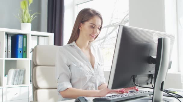 Młoda kobieta pracuje w biurze za pomocą komputera. Miejsce pracy przedsiębiorcy, menedżera lub bizneswoman. Koncepcja pracy zdalnej i edukacji. — Wideo stockowe