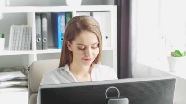 Jonge vrouw werkt op kantoor met behulp van de computer. Werkplaats van ondernemer, manager of zakenvrouw. Concept telewerken en onderwijs. — Stockvideo