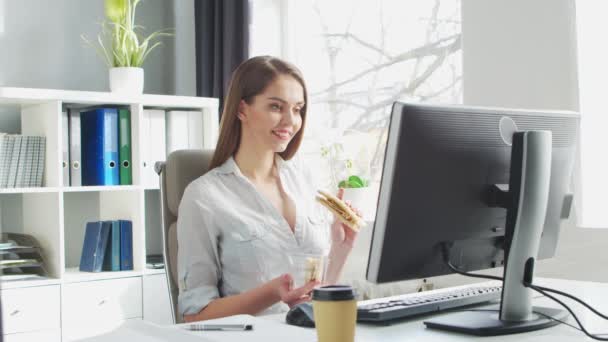 Η νεαρή γυναίκα τρώει μεσημεριανό στο γραφείο. Χώρος εργασίας του επιχειρηματία, διευθυντής ή επιχειρηματίας. Πάρτε μακριά Τροφίμων και Υγιεινής Διατροφή στην Εργασία Concept. — Αρχείο Βίντεο