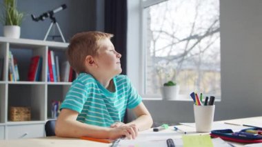 Çocuk Masa 'da ödevini yapıyor. Şirin Çocuk, Ders kitapları ve okul malzemelerinin yardımıyla evde öğreniyor. Öğrenim ve Eğitim Konsepti.