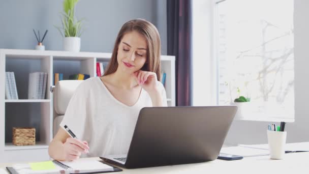 Jonge vrouw werkt bij Binnenlandse Zaken met behulp van de computer. Werkplaats van vrouwelijke ondernemer, freelancer of student. Concept telewerken en onderwijs. — Stockvideo