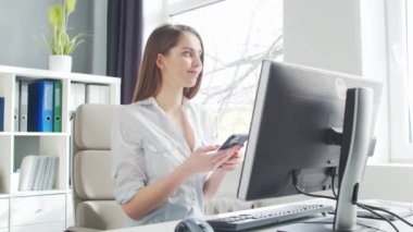 Genç Kadın Ofiste Bilgisayar ve Akıllı Telefon Kullanarak Çalışıyor. Girişimci, Yönetici ya da İş Kadını 'nın işyeri. Uzaktan Çalışma ve Eğitim Konsepti.