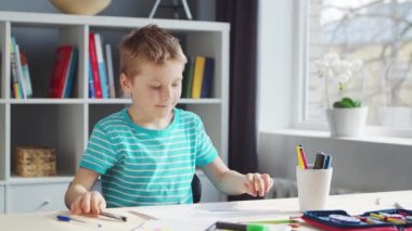 Çocuk Masa 'da ödevini yapıyor. Şirin Çocuk, Ders kitapları ve okul malzemelerinin yardımıyla evde öğreniyor. Öğrenim ve Eğitim Konsepti.
